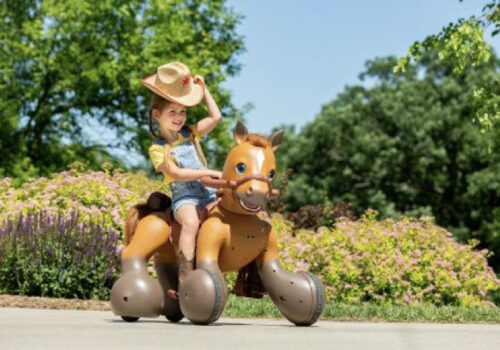 photo of a young child riding a KidTrax Rideamals Scout outside