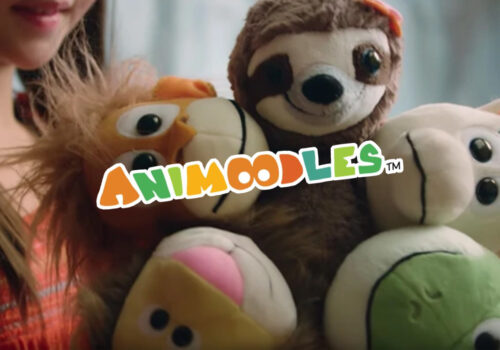 photo of a young child holding an animoodles toy with the animoodles logo in front